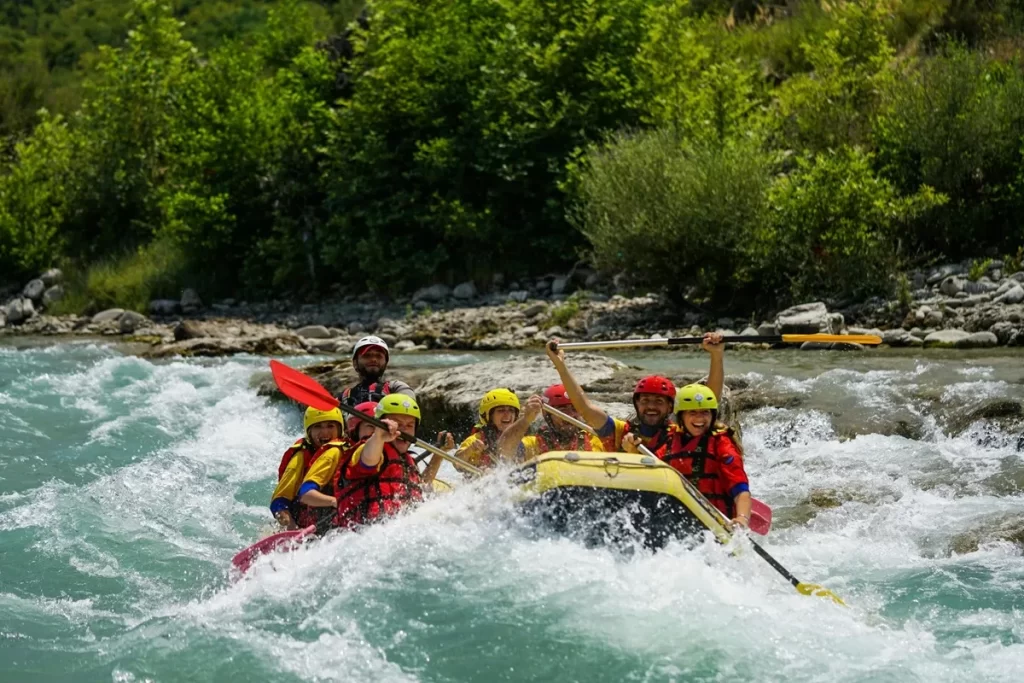 Grupo de pessoas praticando rafting em um rio de águas cristalinas em Bonito, com coletes salva-vidas e capacetes coloridos, enfrentando corredeiras emocionantes.