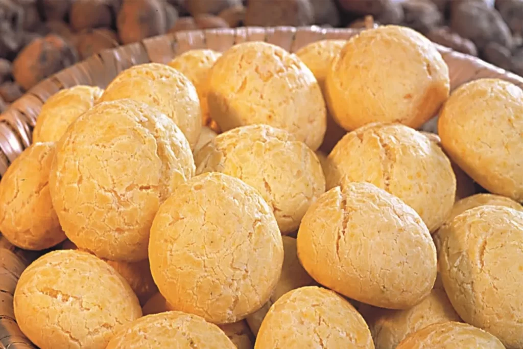 Cesta com várias chipas douradas e crocantes, um pão de queijo típico do Paraguai, dispostas em um recipiente rústico.