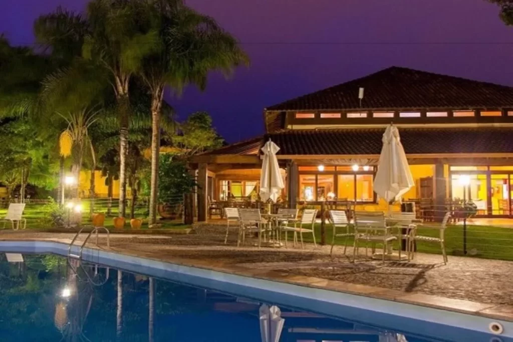 Hotel Pousada Águas de Bonito à noite, com piscina iluminada e área de lazer externa.