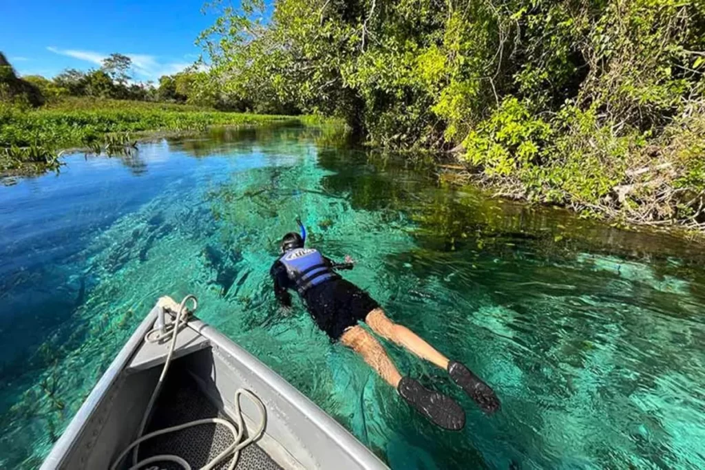 Homem praticando flutuação em um rio de águas cristalinas, com a palavra-chave "cidade de Bonito".